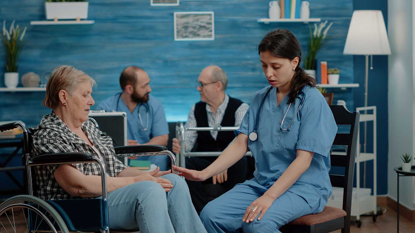 nurse-consulting-retired-woman-sitting-wheelchair-nursing-home-clinic-medical-assistant-doing-healthcare-checkup-with-disabled-old-patient-treatment-recovery-from-painn
